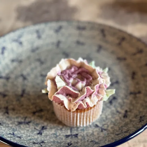 Witte chocolade cupcake met blauwe bessen roos